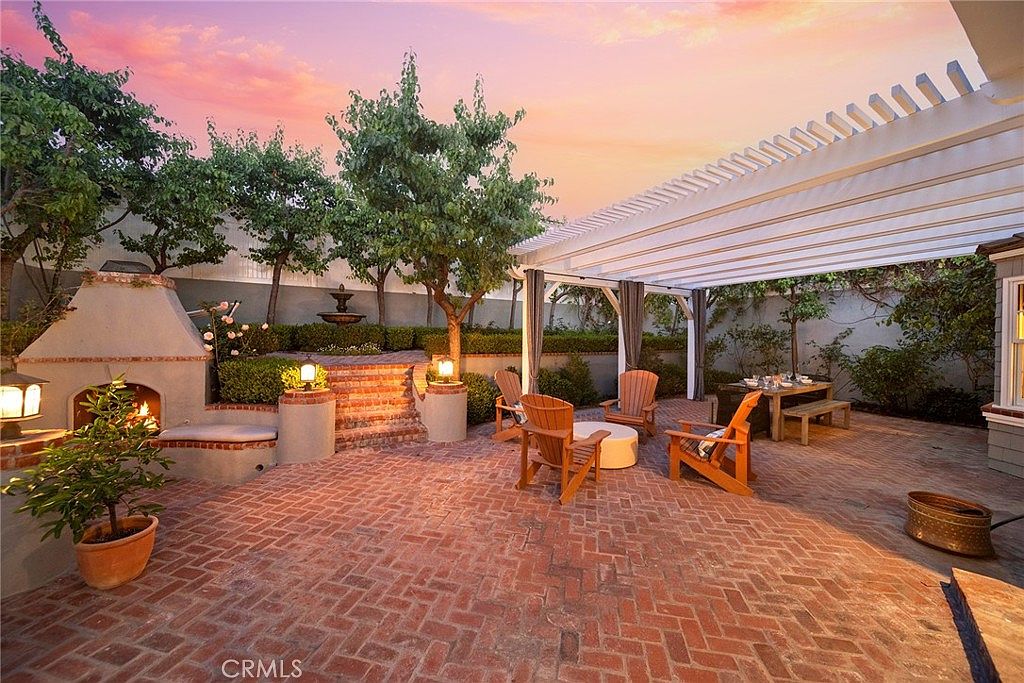 Pergola garden with fireplace and Adirondack chairs at sunset