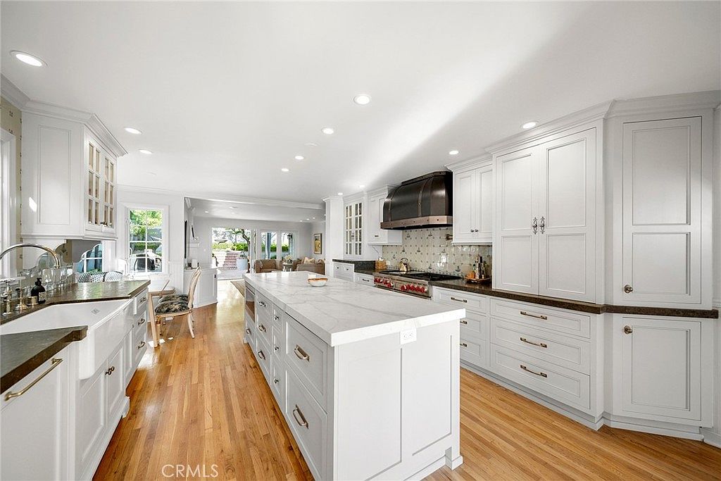 Chef's kitchen with marble island, pro range, and white cabinetry